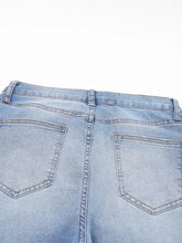 Back view of light-wash denim whiskered wash raw hem cropped jeans with classic pocket design and visible stitching