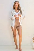 Beige cotton shorts with drawstring waist, pockets, and hooded bomber accents