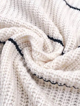 Cream-colored knit long sleeve cardigan sweater with black striped open trim