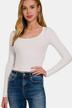 Woman in white short sleeve crop top with flattering neckline and blue jeans