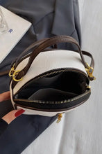 Elegant cream and black leather handbag with gold hardware