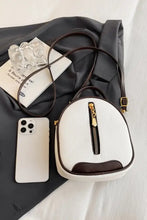 White faux leather handbag with brown trim and gold zipper