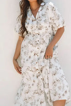 White floral button-up dress with puff sleeves, pockets, and high-low hem