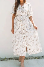 White floral print maxi dress with short sleeves, side slit, and pockets