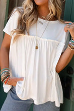 Woman in white frill round neck short sleeve tunic top and blue jeans