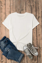 White Made in America graphic t-shirt with knot front, jeans, and sneakers
