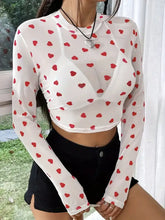 White mesh crop top with red heart pattern and black shorts