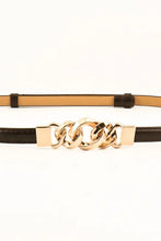 White skinny belt with gold chain buckle and black leather strap