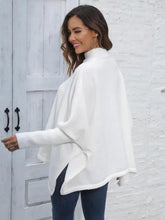 Woman in white turtleneck poncho sweater