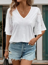 White v neck blouse with lace sleeves, denim shorts, black handbag