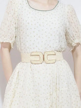 Cream polka dot dress with puff sleeves and tan wide braid belt