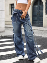 Wide leg cargo jeans in blue denim featuring multiple pockets and side straps for a functional style