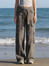 Gray wide leg cargo jeans with multiple pockets and a tied waistband designed for comfortable wear