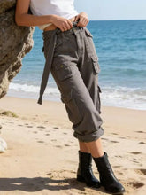 Wide leg cargo jeans in gray featuring multiple pockets and a drawstring waistband for versatile wear