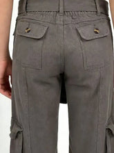 Gray wide leg cargo jeans with a relaxed fit, gold-toned button front pockets, and large side cargo pockets