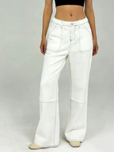 White wide leg jeans with black contrast stitching and flared silhouette showcasing wide leg contrast design
