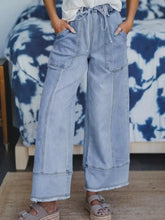 Light-wash denim wide leg drawstring raw hem jeans with frayed hems and a comfortable drawstring waist