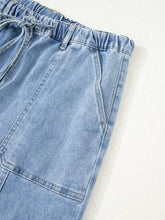 Light-wash denim wide leg drawstring raw hem jeans with elastic waistband and adjustable leg drawstring detail
