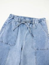 Light-wash denim wide leg drawstring jeans with elastic waistband and raw hem detail