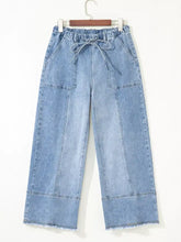 Light-wash denim wide leg drawstring jeans with elastic waistband and raw hem frayed edges