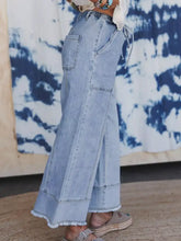 Light-wash denim wide leg drawstring jeans with raw hem frayed edges and side pockets for casual wear