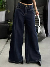Dark blue wide leg jeans in denim with contrasting white stitching and classic five-pocket design