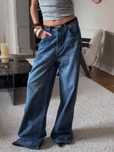 Wide leg relaxed fit medium blue denim jeans with high waist five-pocket design and brown leather belt