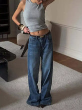 Wide leg relaxed fit blue denim jeans with dark brown belt and gold tone buckle for casual wear