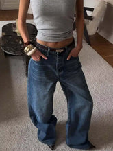 Wide leg relaxed fit jeans in medium blue denim with classic five-pocket design and dark brown leather belt