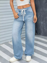Light-wash denim wide leg washed jeans with a white drawstring waistband for a comfortable fit