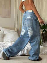 Light-wash denim wide leg washed jeans with distressed ripped details and relaxed wide-leg silhouette
