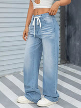 Light-wash denim wide leg washed jeans with high-rise fit and white drawstring waistband for casual wear