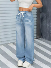 Light-wash denim wide leg washed jeans with a white drawstring waistband for casual wear
