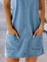 A light blue wide strap denim overall dress with two front pockets made of soft denim material