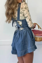 Wide strap square neck denim overalls dress with ruffled hem over floral top