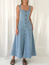 Light blue denim dress with wide strap sweetheart neck, front button closure, and two patch pockets in midi length