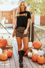 Womens black spooky t shirt with orange text, leather skirt, knee-high boots