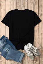 Womens black t-shirt with rhinestone smiley face, jeans, and sneakers