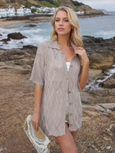 Woman in eyelet collared neck knit top with moderate stretch and white shorts