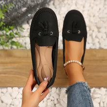 Pair of black PU leather flat loafers with tassel details and cushioned insoles