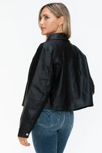 Woman in black cropped leather jacket and jeans