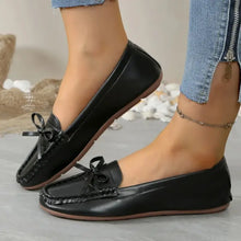 Black leather round toe flats with bow detail and fringe trim
