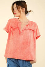 Woman in washed knit fabric short sleeve top with gathered yoke, coral henley