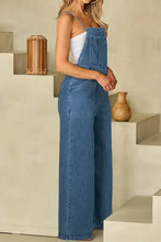 Woman in wide leg denim overalls with adjustable tie straps