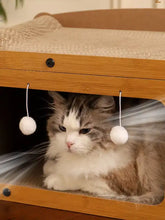 Casa de madera para gatos con rascador beige y juguetes de pompones
