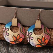 Two wooden flower round shape earrings with floral-patterned cutouts