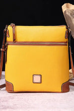 Textured yellow leather crossbody bag with brown trim and front zip pocket