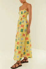 Yellow printed square neck maxi dress with spaghetti straps and brown sandals