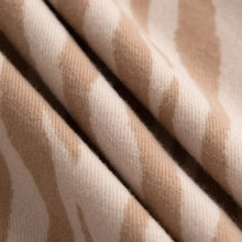 Close-up of beige and brown striped animal print polyester scarf roll