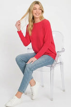 A vibrant red zenana hacci dolman sleeve boat neck top with long sleeves and a relaxed fit knit fabric